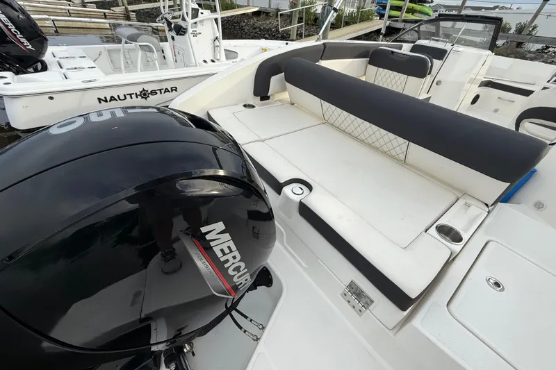 Slide: The Image of 2023 Bayliner DX 2200 boat with Mercury outboard engine and spacious seating area. - 12