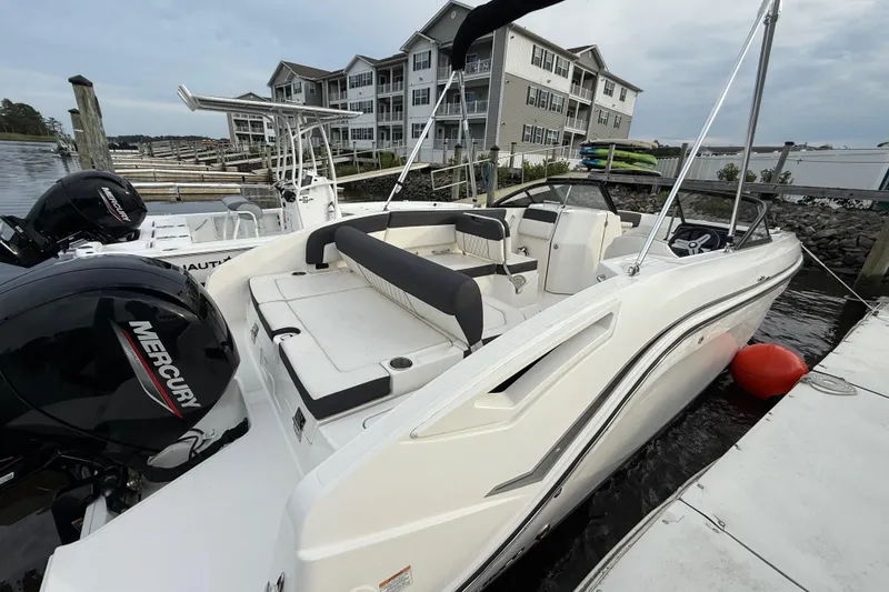 Slide: The Image of 2023 Bayliner DX 2200 boat docked, featuring a Mercury engine and modern design. - 4