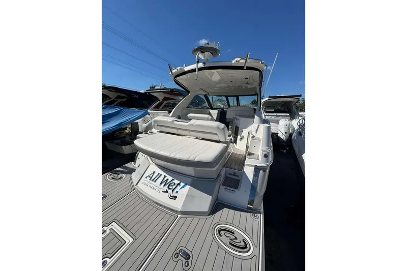 Slide: The Image of 2019 Regal 3350 Sport Cruiser with spacious deck and seating, docked under clear blue sky. - 5