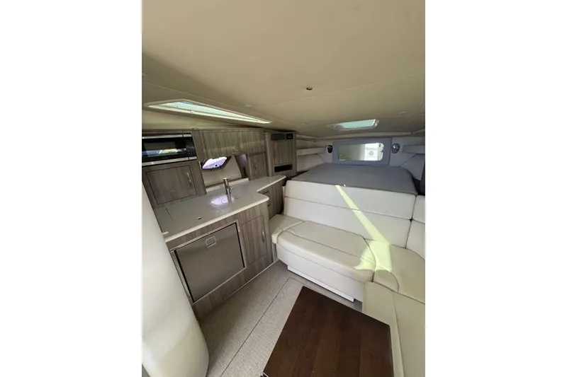 Slide: The Image of 2019 Regal 3350 Sport Cruiser interior with modern kitchen and cozy seating area. - 6
