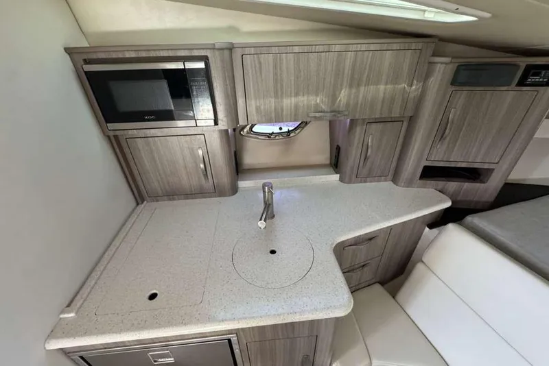 Slide: The Image of 2019 Regal 3350 Sport Cruiser interior kitchen with modern cabinetry and appliances. - 7