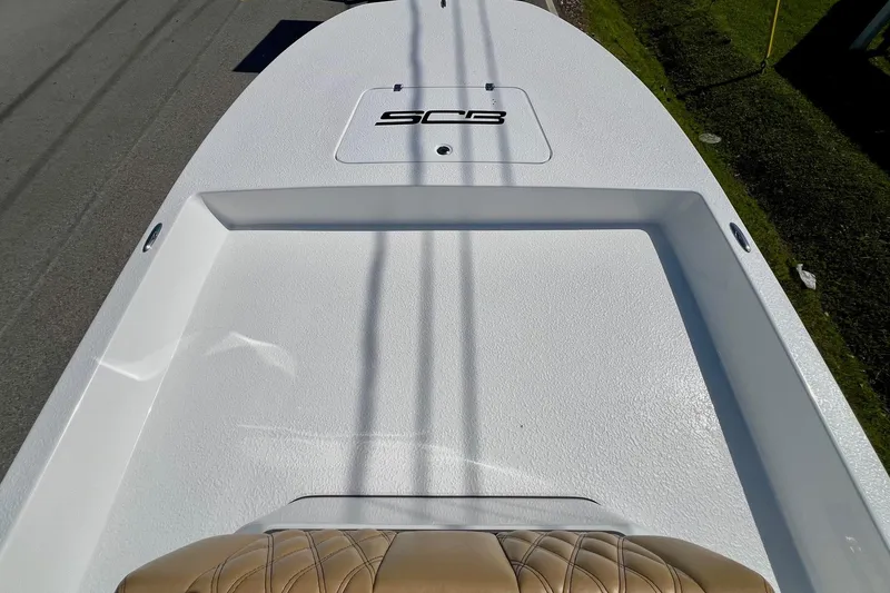 Slide: The Image of 2025 SCB S22 boat deck with logo, featuring textured white surface and tan seating. - 12