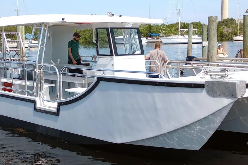 Slide: The Image of Custom Passenger Catamaran BYD34, 2026 model, docked with people onboard, sunny day. - 12