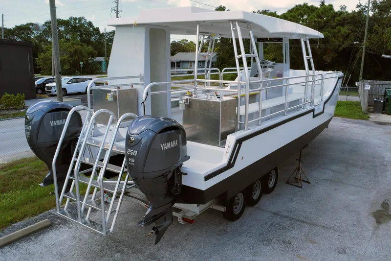 Slide: The Image of Custom Passenger Catamaran BYD34 2026 with dual Yamaha engines on a trailer. - 2