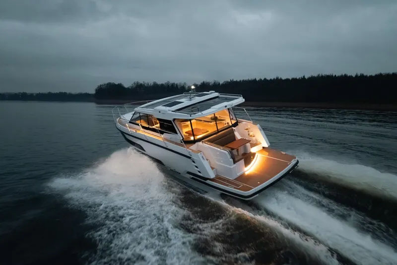 Slide: The Image of 2026 Aquador 400HT yacht cruising on a serene lake at dusk. - 2
