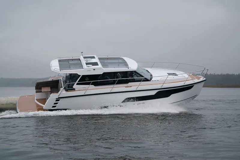Slide: The Image of 2026 Aquador 400HT luxury yacht cruising on a calm, overcast day. - 4
