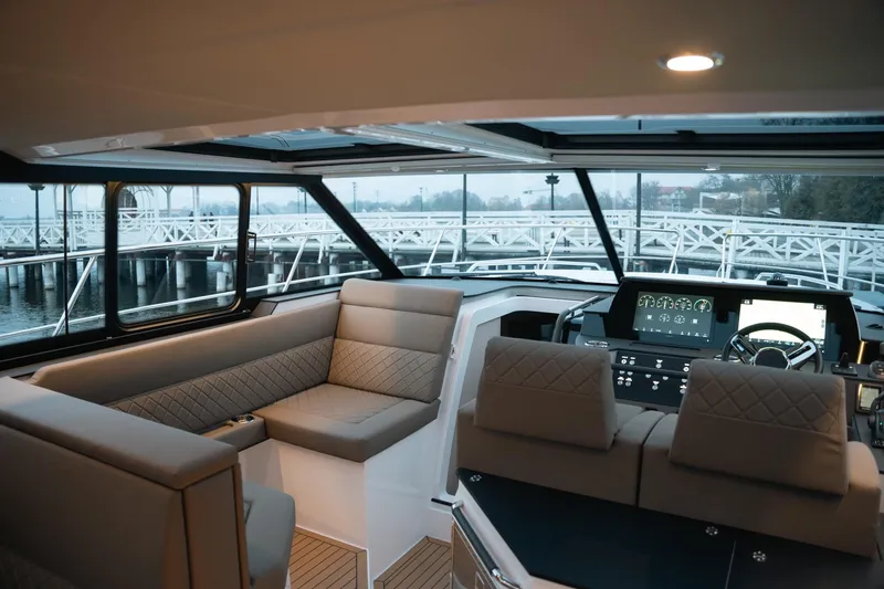 Slide: The Image of Interior of 2026 Aquador 400HT yacht with modern seating and navigation controls. - 9