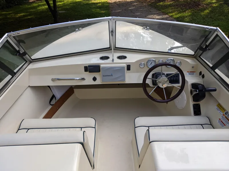 Slide: The Image of 2022 Rossiter 17 boat interior with steering wheel and dashboard controls. - 4