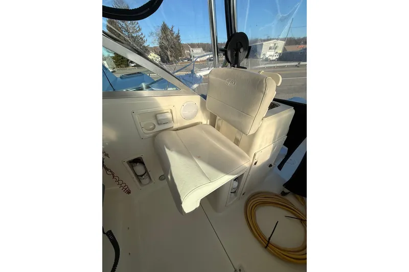 Slide: The Image of 2005 Pursuit 3070 Offshore boat interior with white captain's chair and control panel. - 10