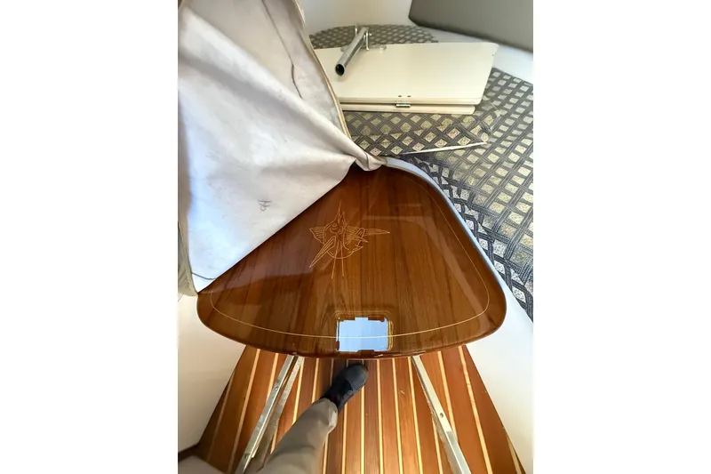 Slide: The Image of 2005 Pursuit 3070 Offshore boat interior with polished wooden table and engraved marlin design. - 16
