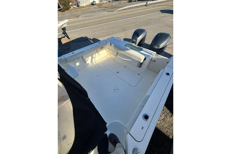 Slide: The Image of 2005 Pursuit 3070 Offshore boat deck with twin engines, parked on roadside. - 3