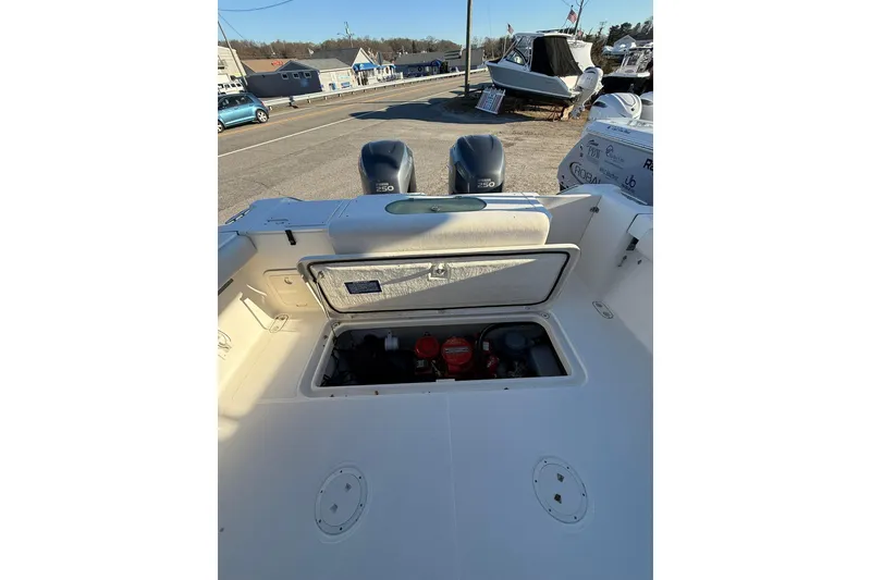 Slide: The Image of 2005 Pursuit 3070 Offshore boat with open engine compartment, docked outdoors. - 4