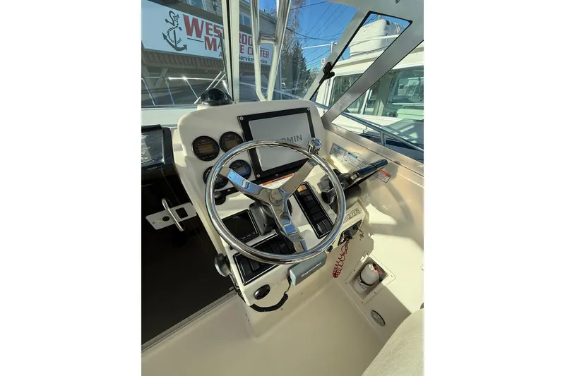 Slide: The Image of 2005 Pursuit 3070 Offshore boat helm with steering wheel and navigation controls. - 7
