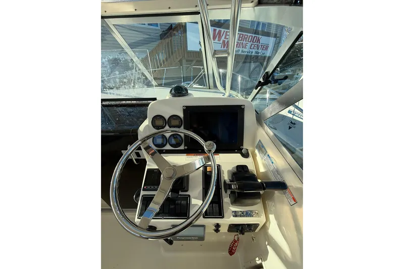 Slide: The Image of 2005 Pursuit 3070 Offshore boat helm with steering wheel and control panel. - 8