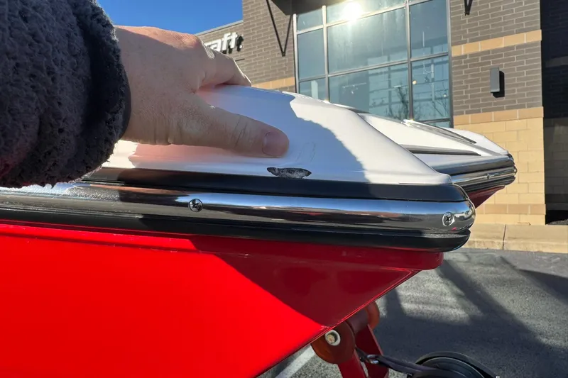 Slide: The Image of 2023 MasterCraft XT20 boat with minor hull damage, parked outside a building. - 6