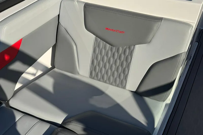 Slide: The Image of 2023 MasterCraft XT20 boat seat with gray upholstery and red logo detailing. - 9