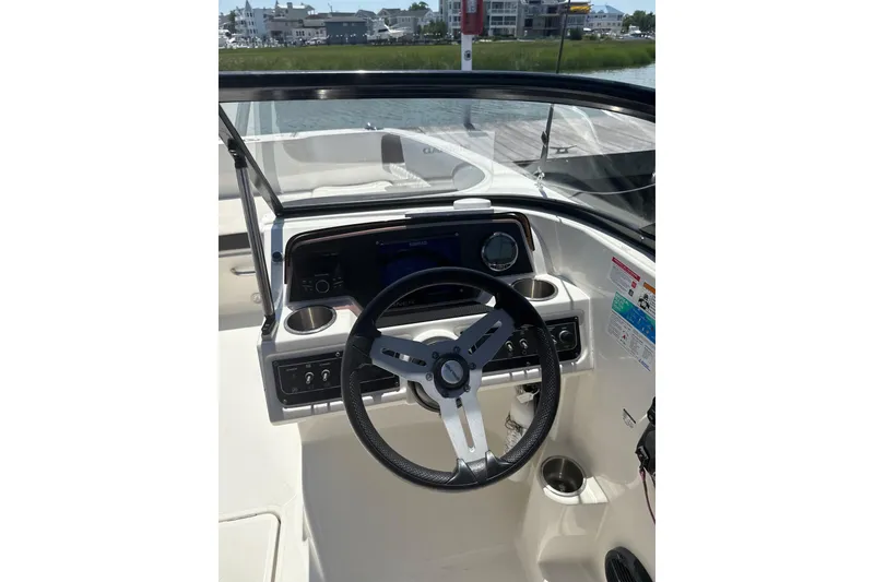 Slide: The Image of 2023 Bayliner DX 2200 boat dashboard with steering wheel and controls. - 4