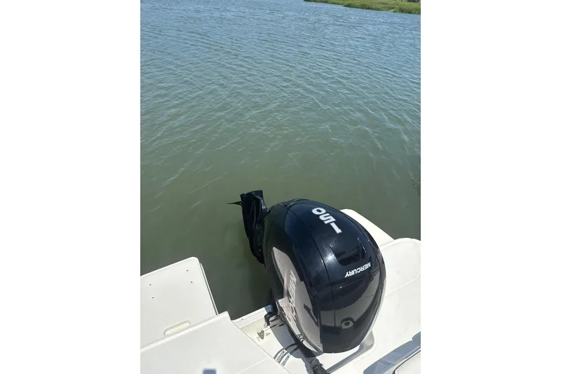 Slide: The Image of 2023 Bayliner DX 2200 with Mercury 150 outboard motor on calm water. - 9