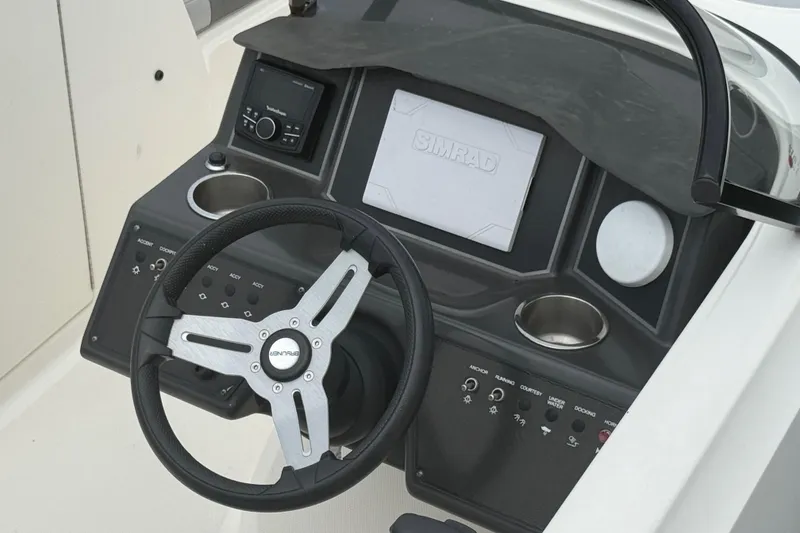 Slide: The Image of 2023 Bayliner VR6 Bowrider OB dashboard with steering wheel and control panel. - 5