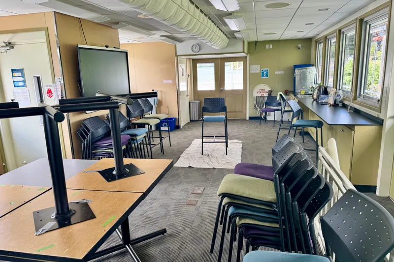 Slide: The Image of Interior of a 2016 Custom Commercial Research Riverboat with stacked chairs and tables. - 15