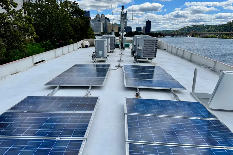 Slide: The Image of Solar panels on a 2016 Custom Commercial Research Riverboat deck, city skyline in background. - 17