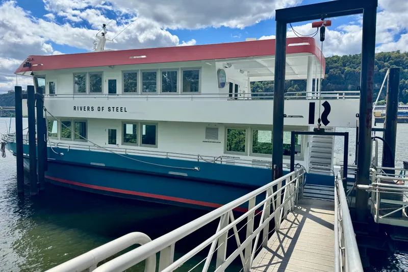 Slide: The Image of Custom 2016 commercial research riverboat docked, named "Rivers of Steel," under a partly cloudy sky. - 4