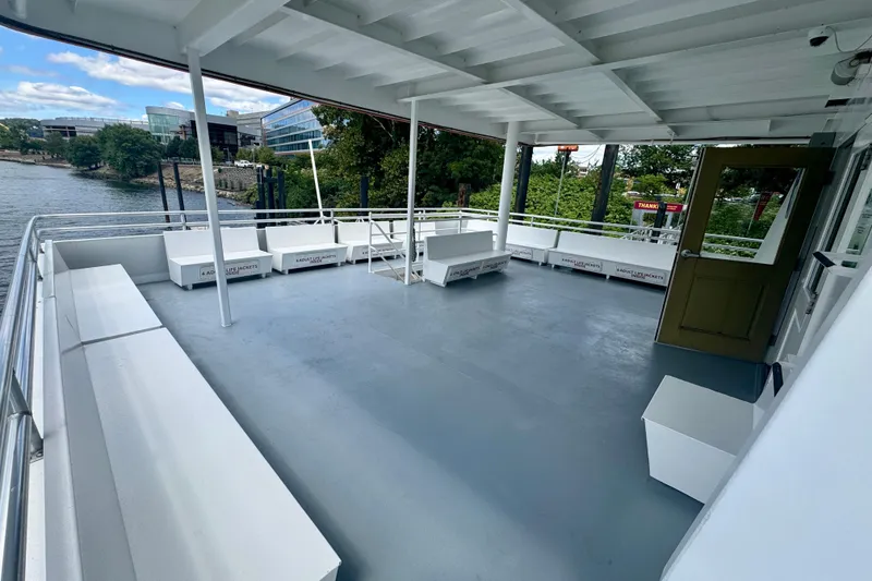 Slide: The Image of Spacious deck of a 2016 Custom Commercial Research Riverboat, docked by a scenic riverside. - 5
