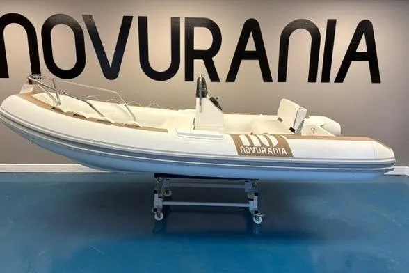 The Image of 2025 Novurania DL 400 boat displayed indoors with contact information sign. - 0