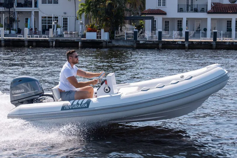 Slide: The Image of 2025 Novurania DL 400 boat displayed indoors with contact information sign. - 4