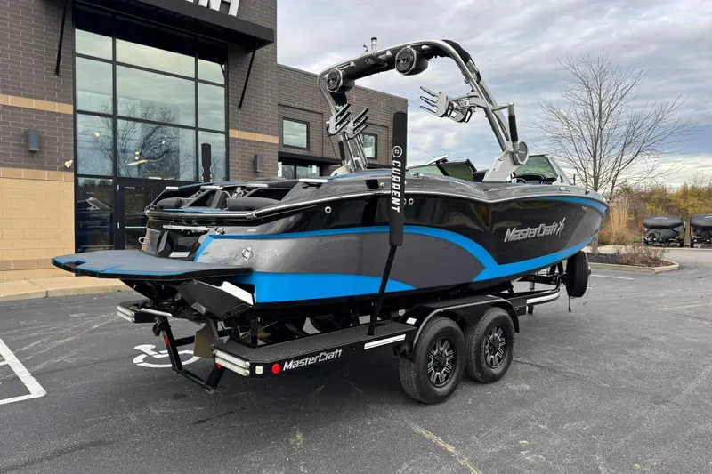 Slide: The Image of 2018 MasterCraft X23 boat on trailer, parked outside a building. - 3