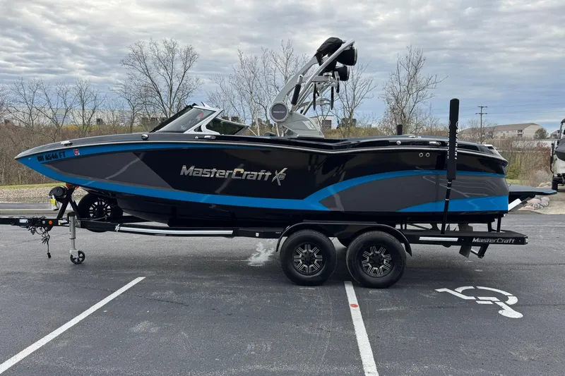 Slide: The Image of 2018 MasterCraft X23 boat on trailer in parking lot, overcast sky. - 6