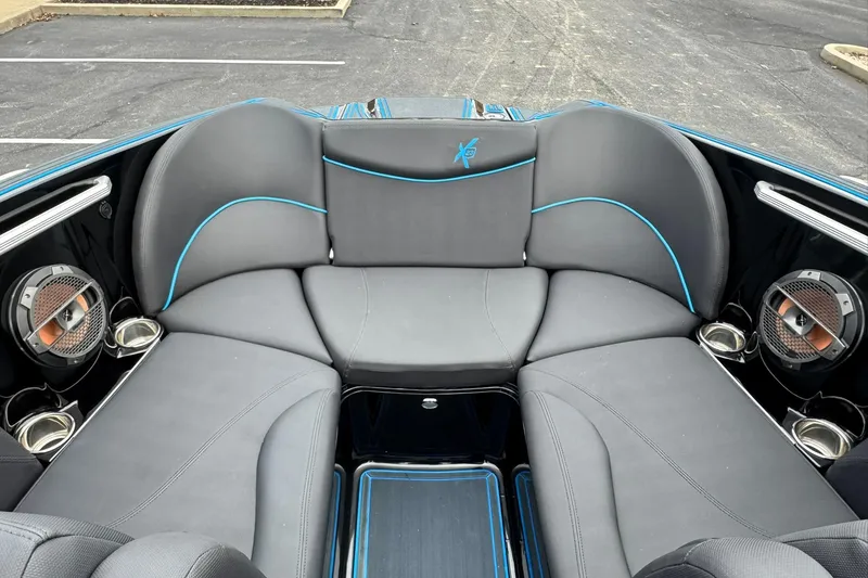 Slide: The Image of 2018 MasterCraft X23 boat interior with gray seating and blue accents. - 8