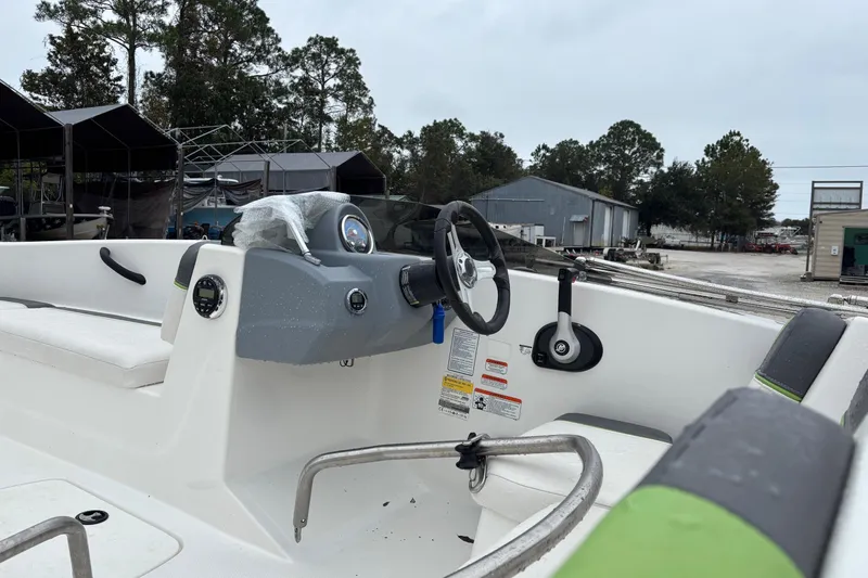 Slide: The Image of 2022 Tahoe T16 boat interior with steering wheel and seating, parked outdoors. - 4