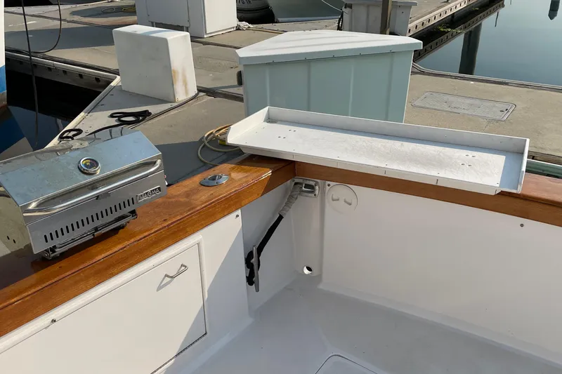 Slide: The Image of 1986 Ocean 38 Super Sport boat with grill and storage at dockside. - 28