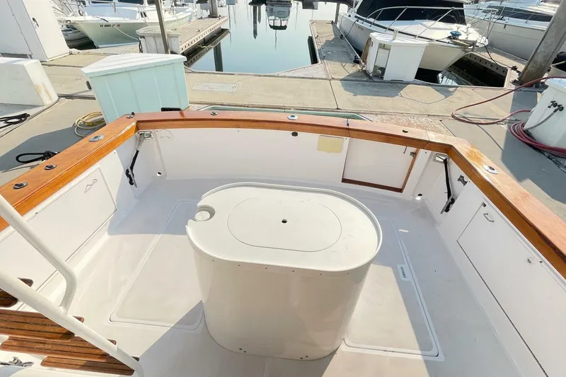 Slide: The Image of 1986 Ocean 38 Super Sport boat deck with wooden trim and storage compartments. - 36