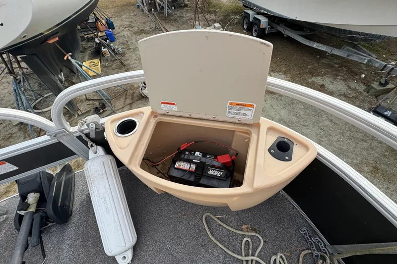 Slide: The Image of Open storage compartment on 2017 Sun Tracker Party Barge 22 Tritoon, showing battery and cup holders. - 27
