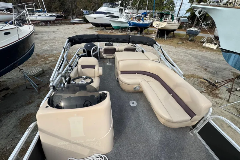 Slide: The Image of 2017 SUNTRACKER TRI-TOON boat with beige seating, parked among other boats. - 31