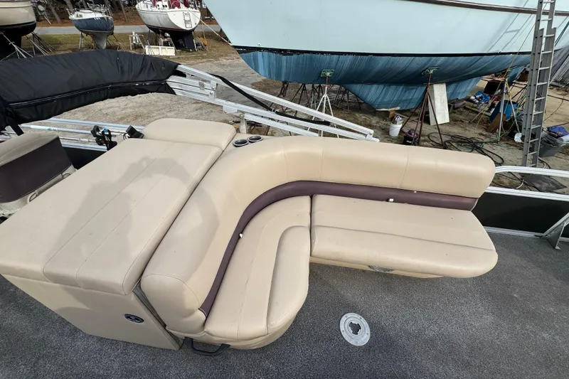 Slide: The Image of 2017 SUNTRACKER TRI-TOON boat with beige seating, docked near other vessels. - 33