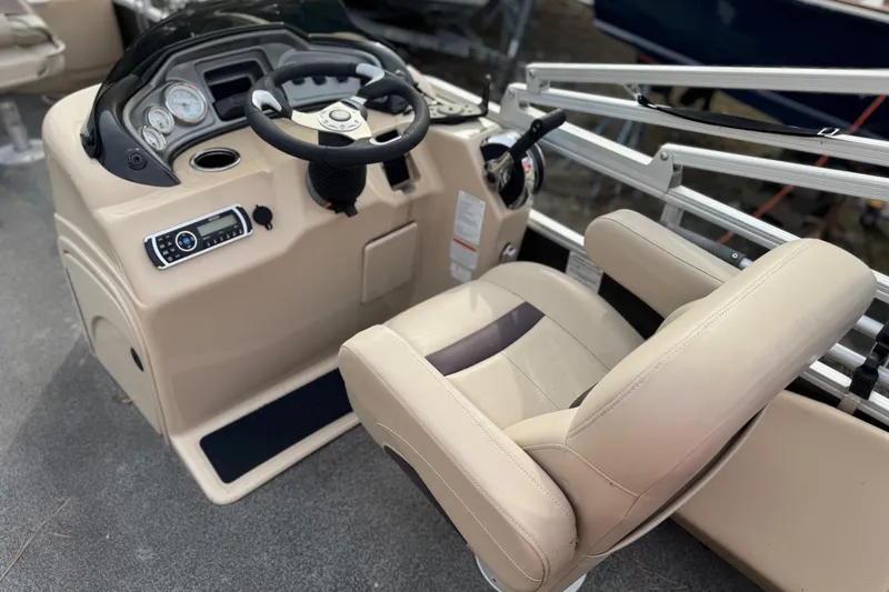 Slide: The Image of 2017 SUNTRACKER TRI-TOON boat console with steering wheel and beige captain's chair. - 34