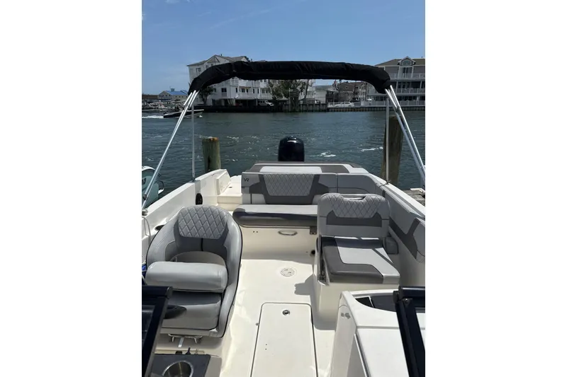 Slide: The Image of 2023 Bayliner VR6 Bowrider OB with spacious seating, docked by waterfront homes. - 2