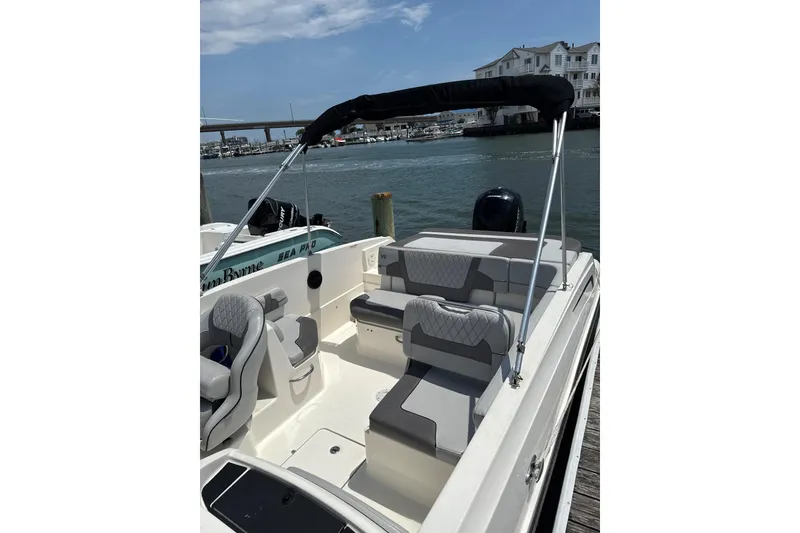 Slide: The Image of 2023 Bayliner VR6 Bowrider OB with sleek seating, docked by waterfront homes. - 3
