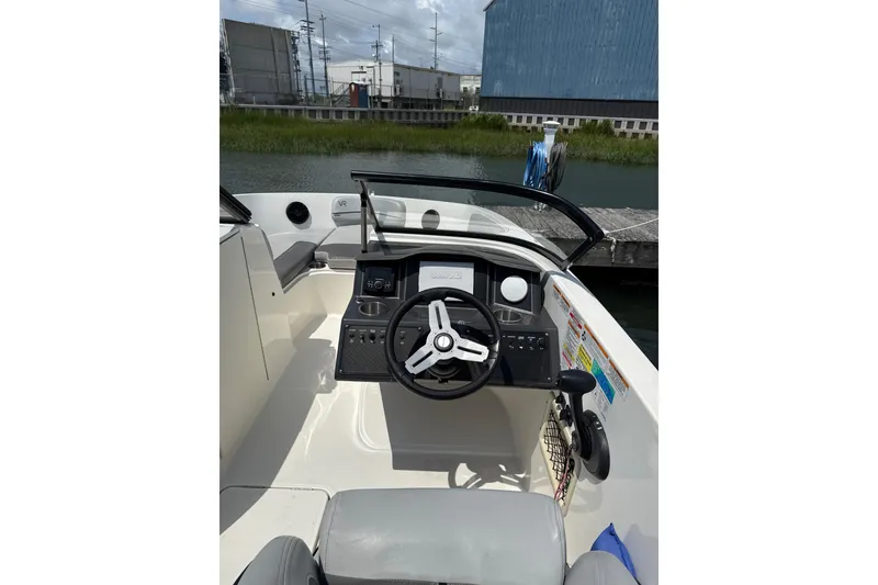 Slide: The Image of 2023 Bayliner VR6 Bowrider OB cockpit with steering wheel and control panel. - 4