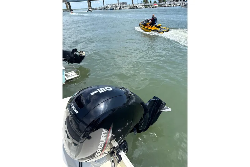 Slide: The Image of 2023 Bayliner VR6 Bowrider OB with Mercury outboard engine on water, jet ski nearby. - 7