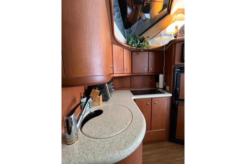 Slide: The Image of 2005 Silverton 34 Convertible yacht kitchen with wood cabinetry and modern appliances. - 17