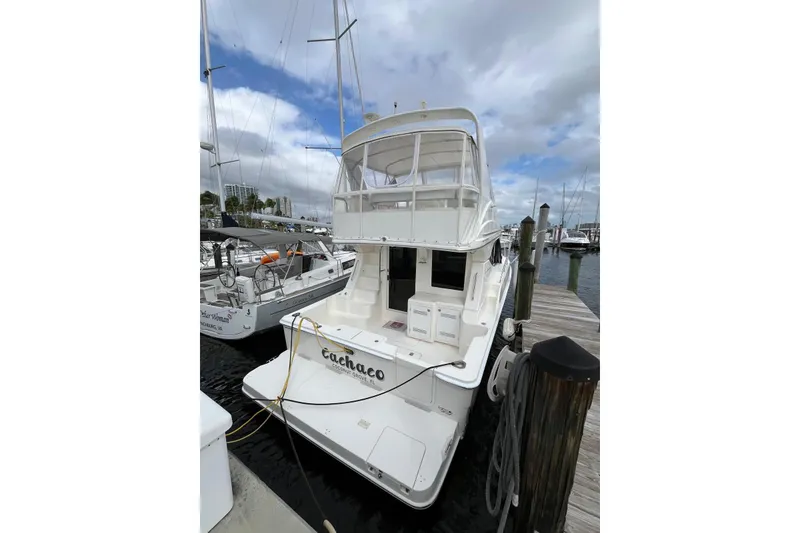 Slide: The Image of 2005 Silverton 34 Convertible yacht docked at marina under cloudy sky. - 19