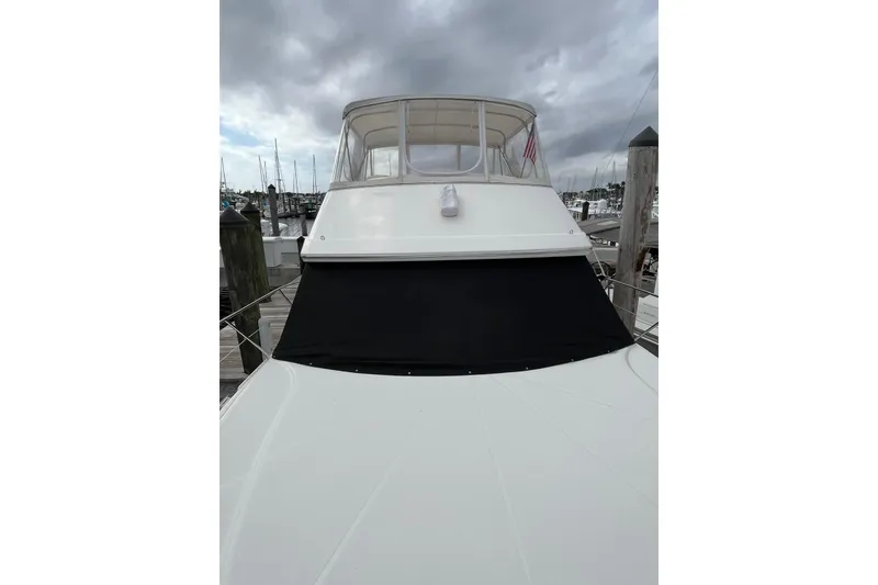 Slide: The Image of 2005 Silverton 34 Convertible yacht docked under cloudy skies. - 2