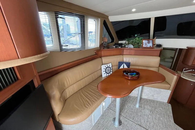 Slide: The Image of Luxurious interior of a 2005 Silverton 34 Convertible yacht with leather seating and wooden table. - 24