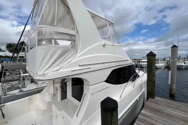 Slide: The Image of 2005 Silverton 34 Convertible yacht docked at marina under cloudy sky. - 33