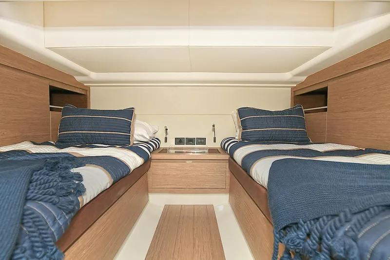 Slide: The Image of 2023 Pardo Yachts 43 cabin with twin beds and blue-striped bedding. - 33