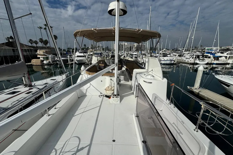 Slide: The Image of 2017 Beneteau Swift Trawler 44 docked in a marina, surrounded by sailboats. - 15